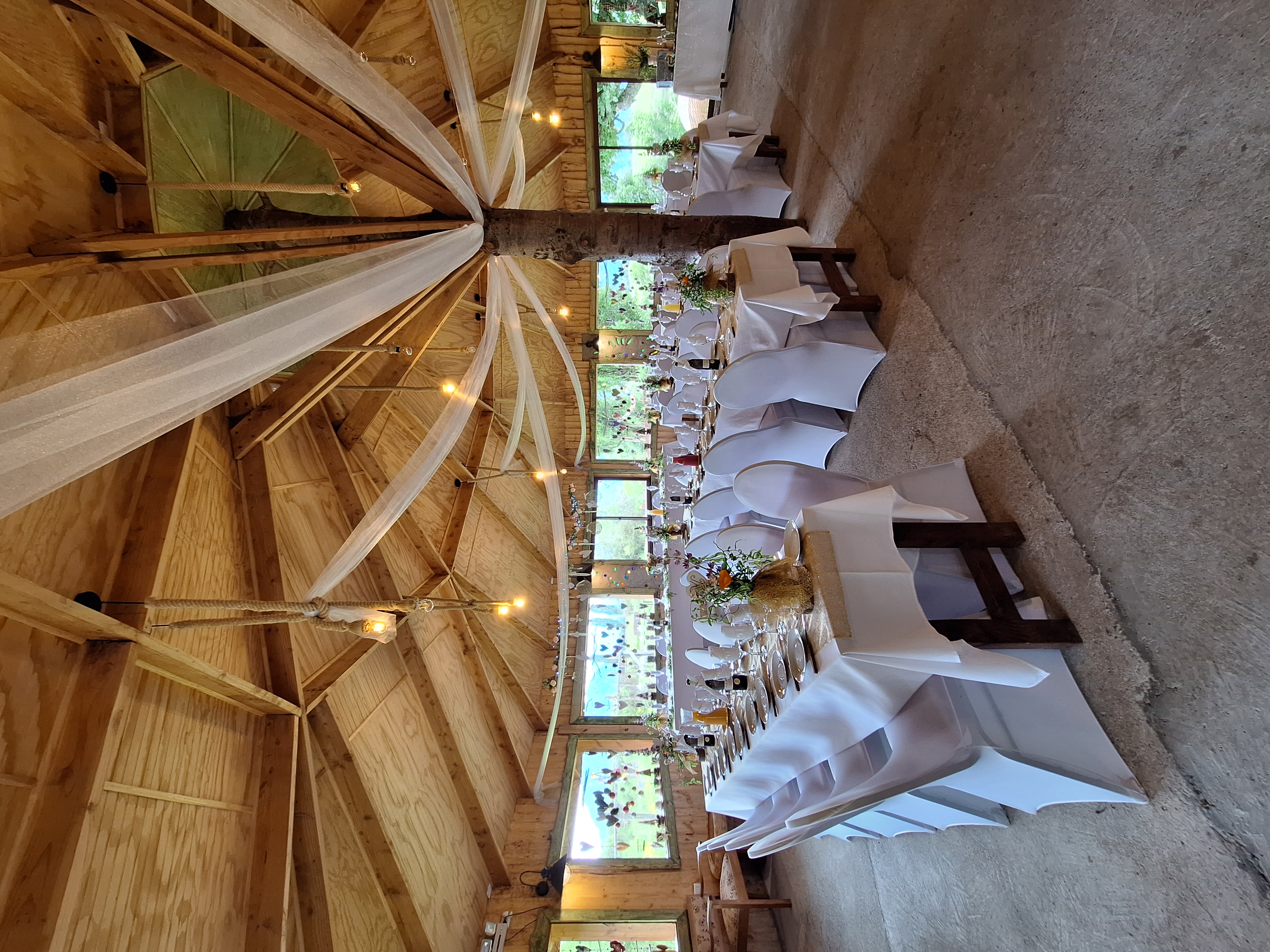 Salón interior decorado para matrimonio con mesas largas y vista al paisaje