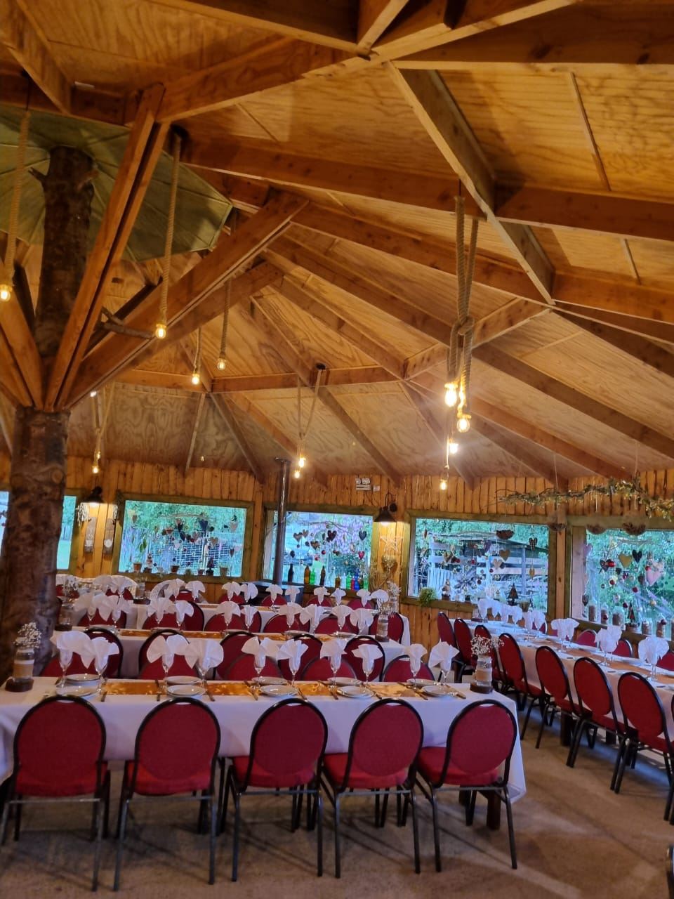Salón principal con mesas largas y sillas rojas