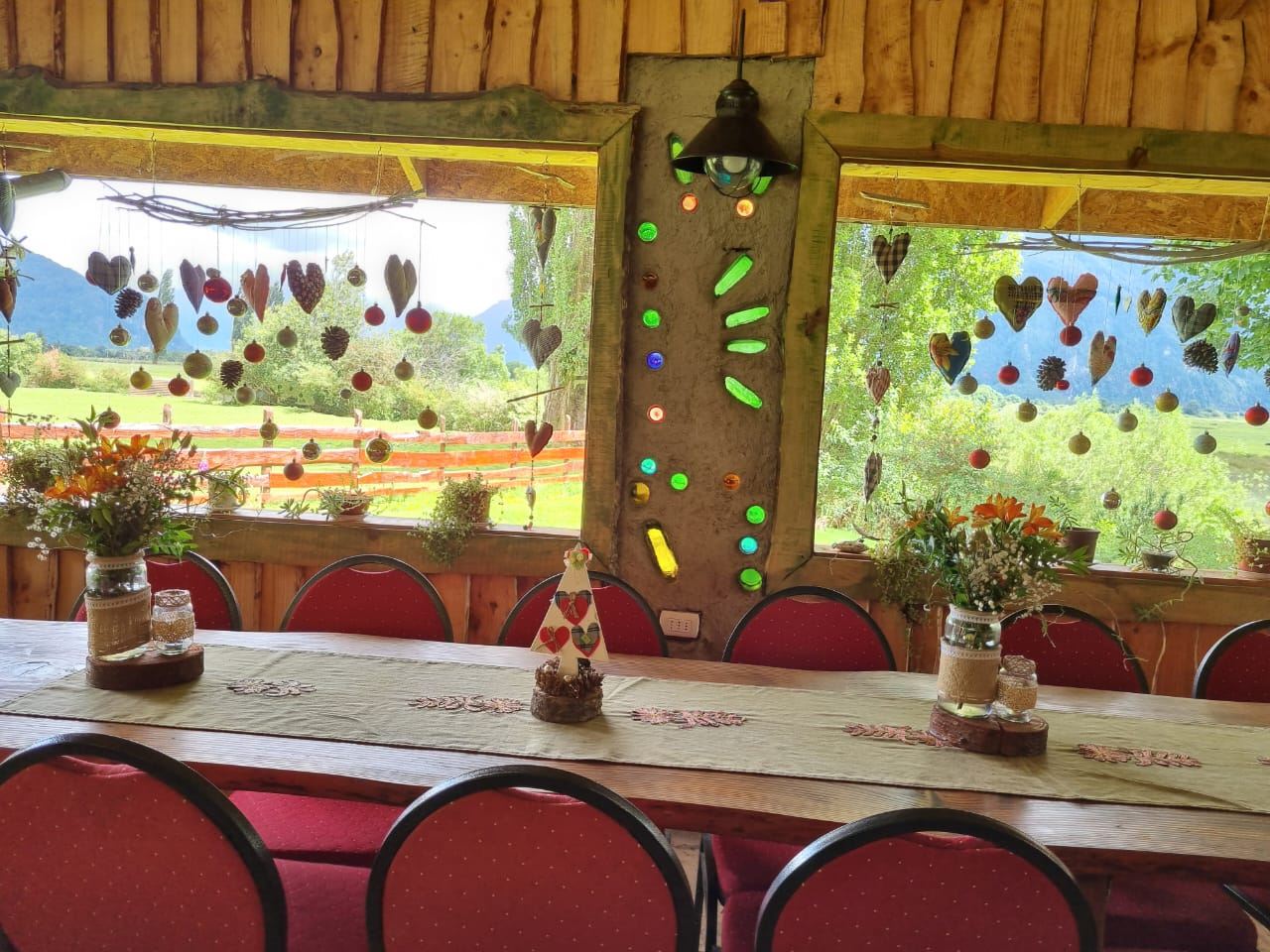 Salón principal de Arribos, Centro de Eventos, con mesas dispuestas y vista a las sierras